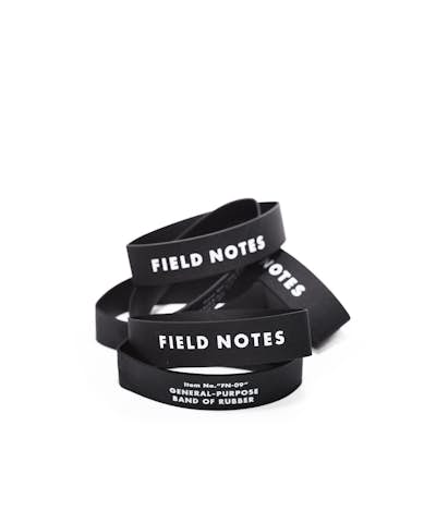 Pile of black rubber bands with white Field Notes logo on each.