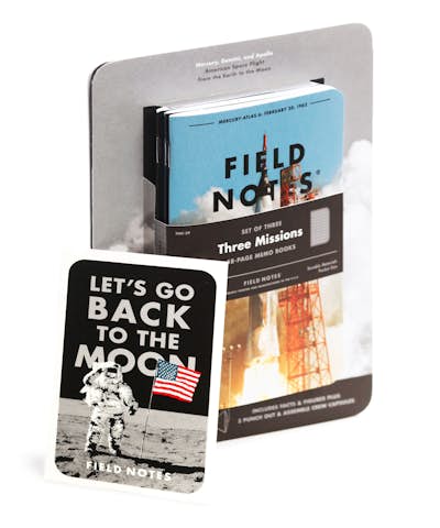Field Notes Three Missions edition at an angle with water transfer decal. The Mercury-Atlas 6 rocket is on the cover.